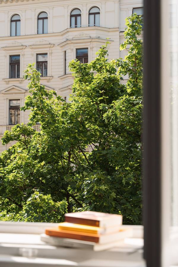 Blick aus dem Praxisfenster auf Baumkronen und eine Gründerzeitfassade